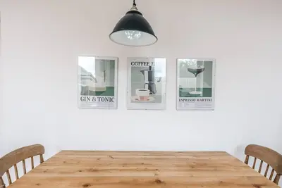 a dining room table with four pictures on the wall at Print Rooms, Leiston in Leiston