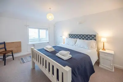 a bedroom with a large bed with towels on it at Print Rooms, Leiston in Leiston