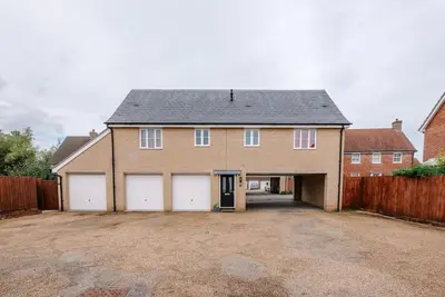 a large brick house with white garage doors at The Little Hopton, Saxmundham in Saxmundham