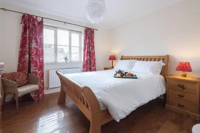 a bedroom with a large white bed and a chair at The Little Hopton, Saxmundham in Saxmundham