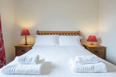 a bedroom with a bed with two towels on it at The Little Hopton, Saxmundham in Saxmundham
