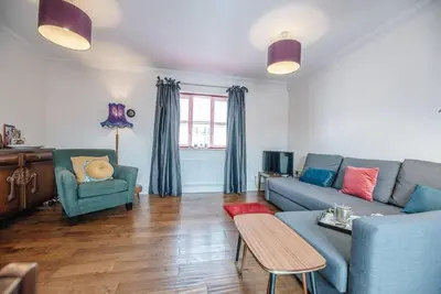a living room with a blue couch and a table at The Little Hopton, Saxmundham in Saxmundham