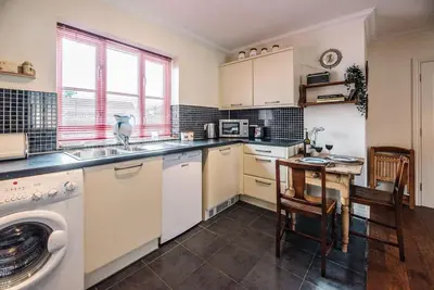 a kitchen with a sink and a table with chairs at The Little Hopton, Saxmundham in Saxmundham