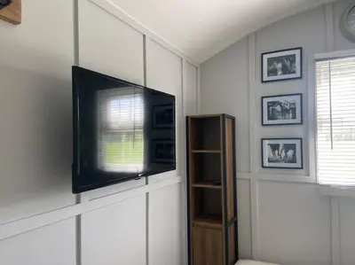 a living room with a flat screen tv on a wall at Beautiful shepherd’s hut in Newmarket