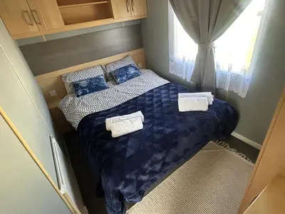 a small bedroom with a bed and a window at Holiday Caravan in Clacton-on-Sea