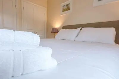 a white bed with white sheets and pillows at Grove Farm Bungalow and Annexe, Dallinghoo in Woodbridge