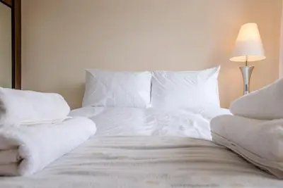 a white bed with white sheets and pillows at Grove Farm Bungalow and Annexe, Dallinghoo in Woodbridge