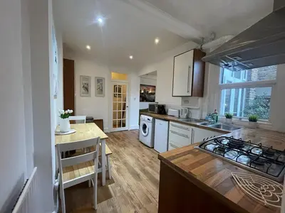 a kitchen with a stove top oven next to a counter at Seaside private garden in Leigh-on-Sea