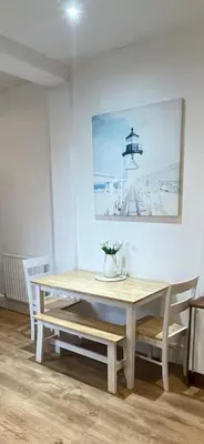 a table and chairs in a room with a picture on the wall at Seaside private garden in Leigh-on-Sea