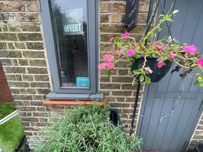 a door with two potted plants next to a house at Seaside private garden in Leigh-on-Sea