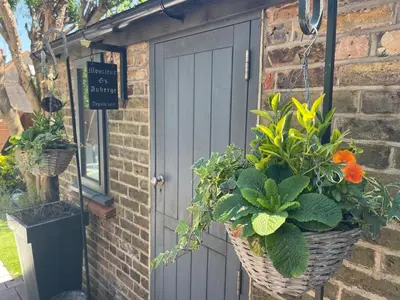 a gray garage door with plants in baskets at Seaside private garden in Leigh-on-Sea