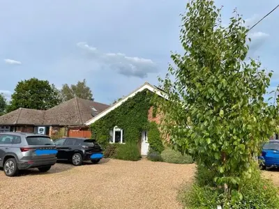 a house with cars parked in front of it at Ferncroft Garden Studio in Histon