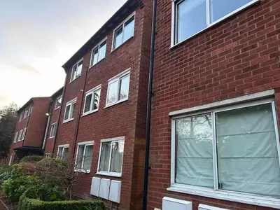 a red brick building with white windows on it at Lady Jane Court in Trumpington