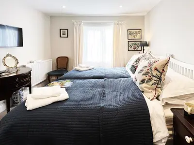 a bedroom with a large bed and a window at Dell View by The Suffolk Cottage Collection in Bentley
