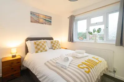 a bedroom with a bed with towels on it at Hollybobs in Leiston