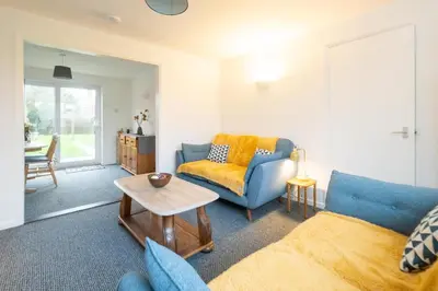 a living room with a couch and a table at Hollybobs in Leiston