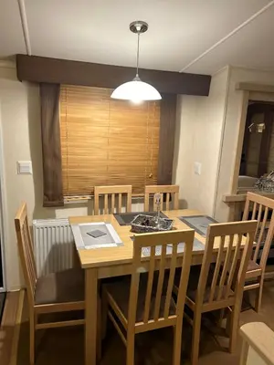 a dining room with a wooden table and chairs at Havah’s in Saint Osyth