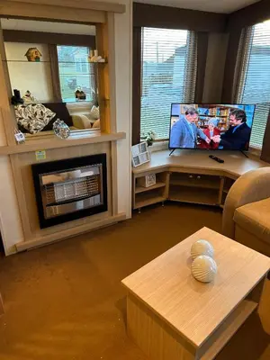 a living room with a fireplace and a flat screen tv at Havah’s in Saint Osyth