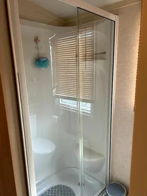 a shower with a glass door in a bathroom at Havah’s in Saint Osyth