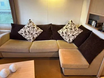 a couch in a living room with pillows on it at Havah’s in Saint Osyth