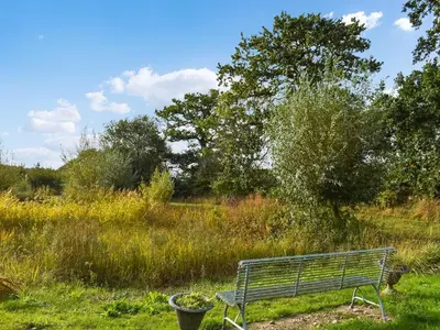 a park bench sitting in a field of grass at Owls Nest in Stradbroke