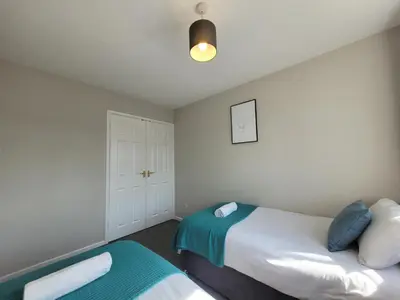 a bedroom with two beds and a closet at Modern 4-Bedroom Contractor Base in Lexden with Parking, WiFi & Quick Access to Sites- Catchpole Stays in Lexden