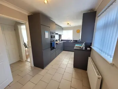 a kitchen with gray cabinets and a tile floor at Modern 4-Bedroom Contractor Base in Lexden with Parking, WiFi & Quick Access to Sites- Catchpole Stays in Lexden