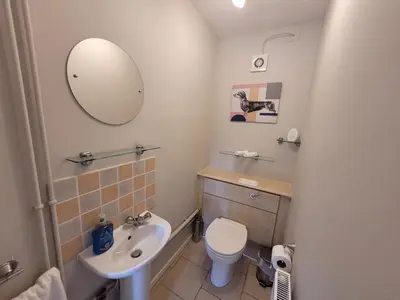 a bathroom with a toilet and a sink and a mirror at Modern 4-Bedroom Contractor Base in Lexden with Parking, WiFi & Quick Access to Sites- Catchpole Stays in Lexden