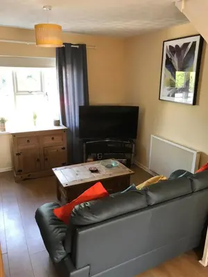 a living room with a couch and a table at Home from Home in our Self-Contained Annexe in Radwinter