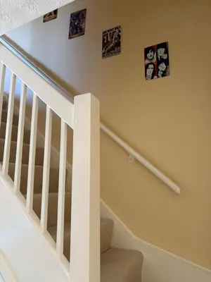 a white staircase with pictures on the wall at Home from Home in our Self-Contained Annexe in Radwinter