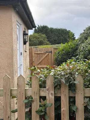 a wooden fence in front of a house with a gate at Home from Home in our Self-Contained Annexe in Radwinter