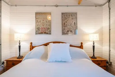 a bedroom with a white bed with two lamps at The Cabin, Parham in Woodbridge