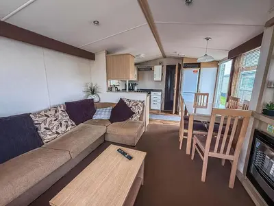 a living room with a couch and a table at Great Caravan On A Family Holiday Park In Essex, Ref 37055G in Clacton-on-Sea