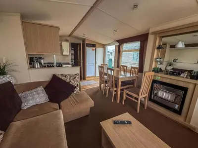 a living room with a couch and a table at Great Caravan On A Family Holiday Park In Essex, Ref 37055G in Clacton-on-Sea