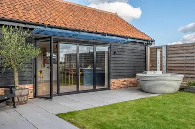 an extension to a house with sliding glass doors at Large immaculate rural conversion - The Milking Parlour in Ipswich