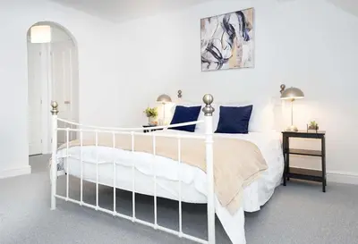 a bedroom with a white bed with blue pillows at Entire House in Ipswich - Handford in Ipswich