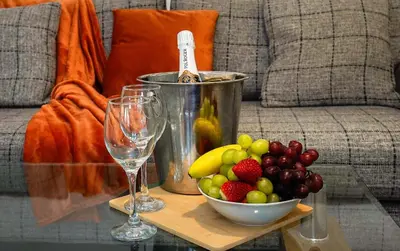 a table with a bowl of fruit and two wine glasses at Entire House in Ipswich - Handford in Ipswich