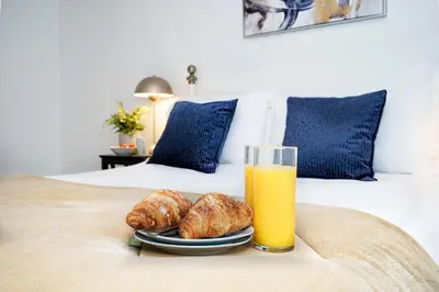a plate of croissants and a glass of orange juice on a bed at Entire House in Ipswich - Handford in Ipswich