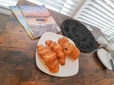 a table with a plate of pastries and a book at 11a Manning Road in Felixstowe