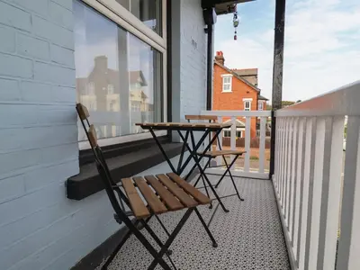 a table and two chairs sitting on a balcony at 11a Manning Road in Felixstowe