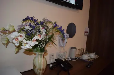 a vase filled with flowers sitting on a table at Star Anglia Hotel City Center by OYO in Colchester