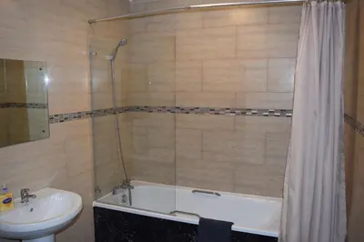 a bathroom with a tub and a sink and a shower at Star Anglia Hotel City Center by OYO in Colchester