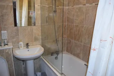 a bathroom with a sink and a tub and a shower at Star Anglia Hotel City Center by OYO in Colchester