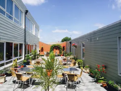 an outdoor patio with tables and chairs and plants at Star Anglia Hotel City Center by OYO in Colchester