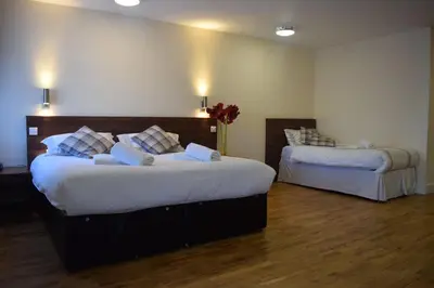 a bedroom with two beds with white sheets at Star Anglia Hotel City Center by OYO in Colchester