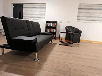 two black chairs in a room with a book shelf at The Annex in Felixstowe