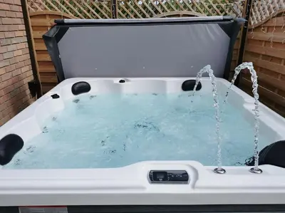 a hot tub with water coming out of it at Woodpeckers - Alresford Essex in Alresford