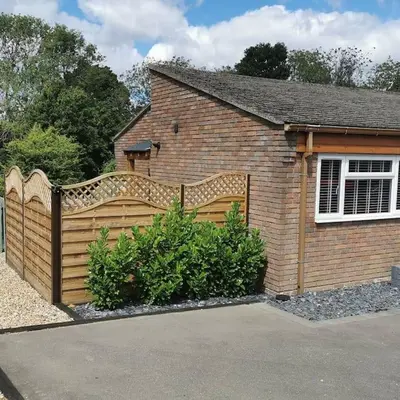 a wooden fence in front of a house at Woodpeckers - Alresford Essex in Alresford