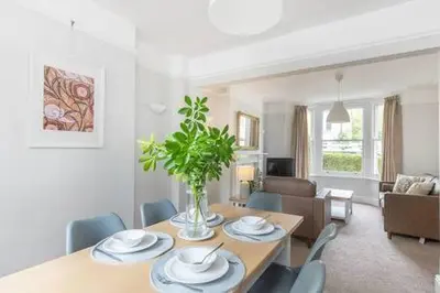 a living room with a dining room table with chairs at Victorian 2 Bedroom Home near the river Cam in Cambridge