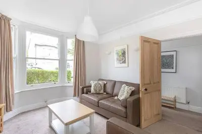 a living room with a couch and a window at Victorian 2 Bedroom Home near the river Cam in Cambridge
